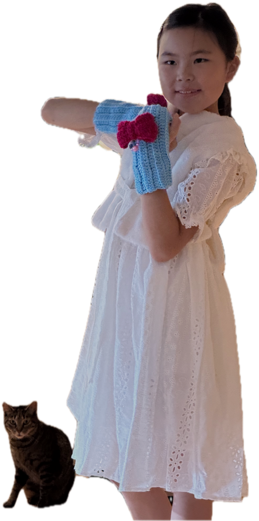 Leona holding a blue crochet creation with Nani beside her